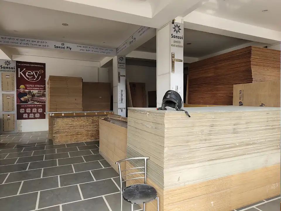 Retail stockroom with light MDF and particle-board stacks beside Sansui plywood