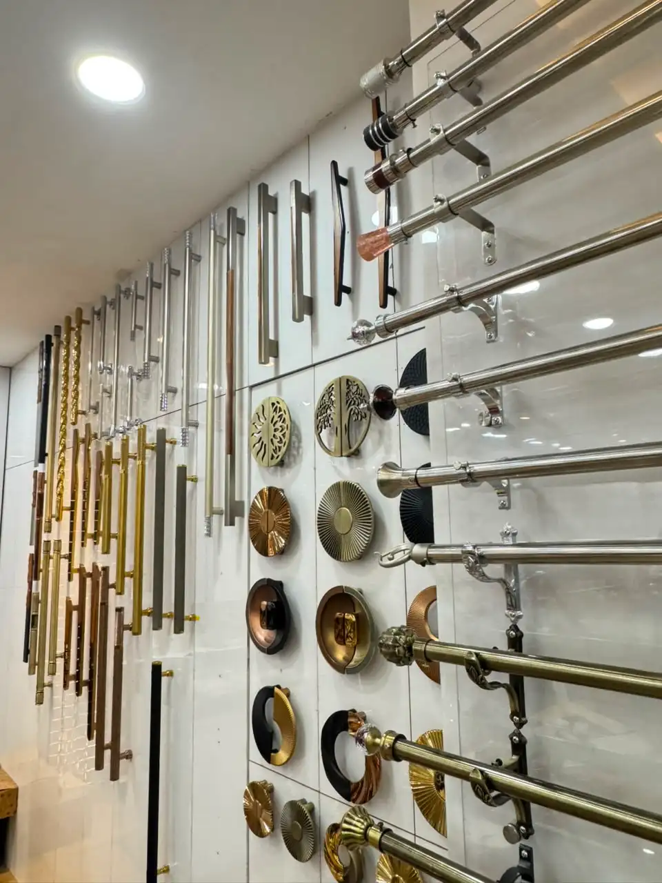 Wall of cabinet pull handles and curtain rods at the showroom