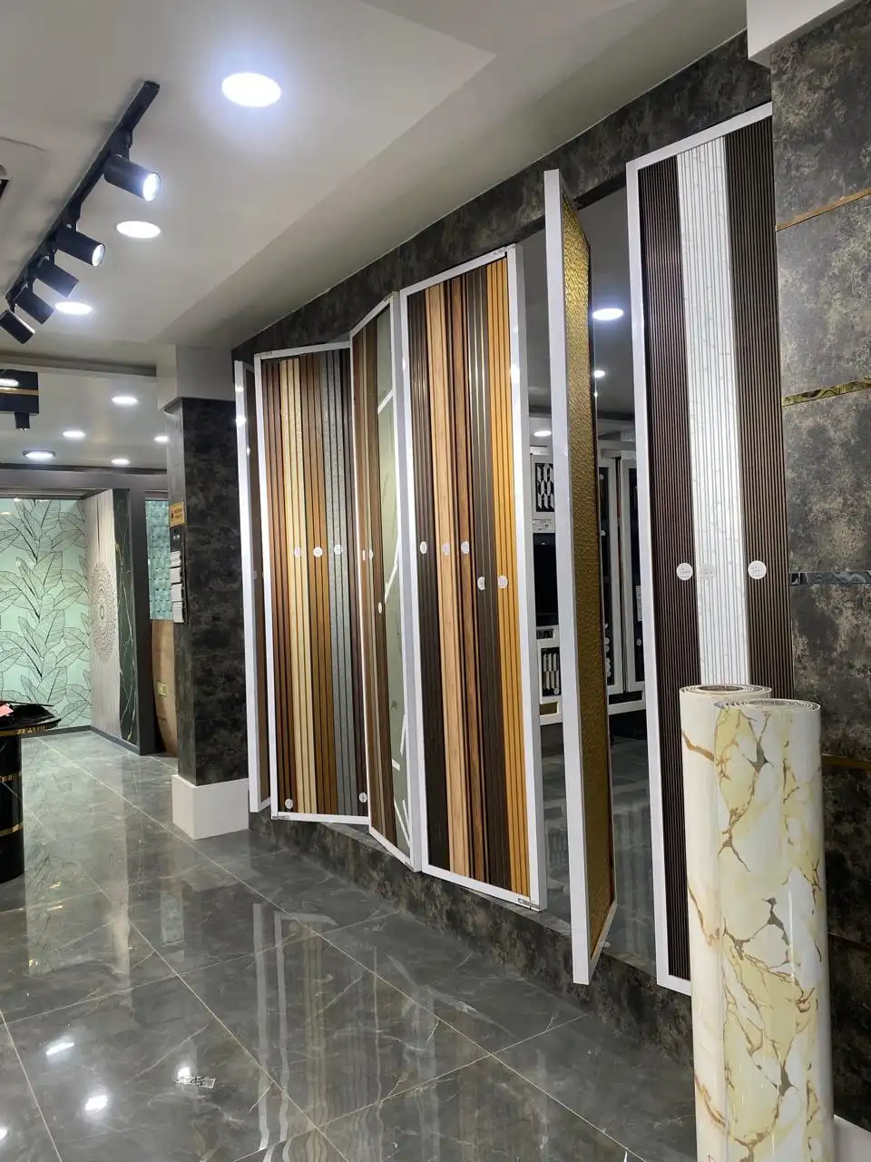 Fluted WPC wall panels and marble-finish PVC rolls on display