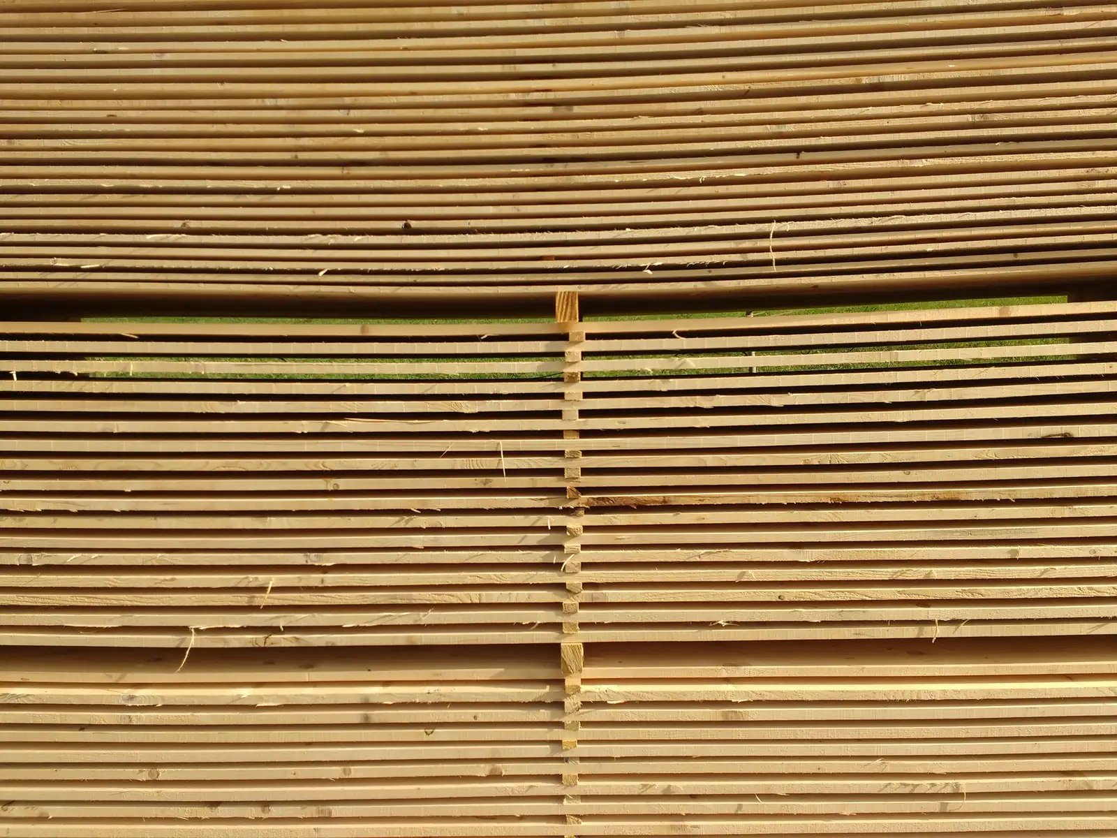 Stacked timber planks in a warm-lit yard